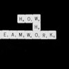 a black and white photo of scrabble tiles spelling the word teamwork