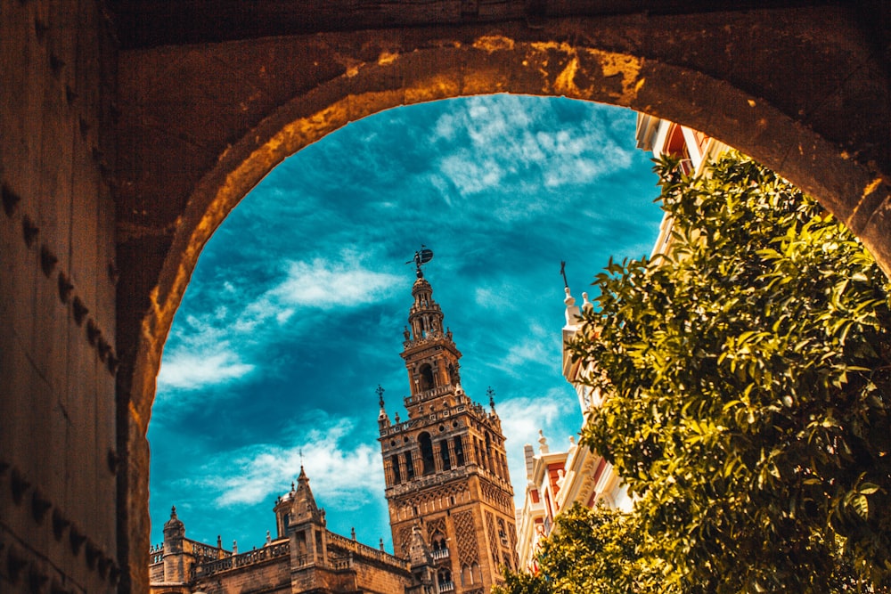 edifício de concreto marrom sob céu azul e nuvens brancas durante o dia