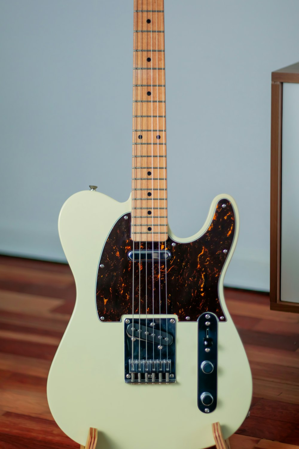 white and brown stratocaster electric guitar