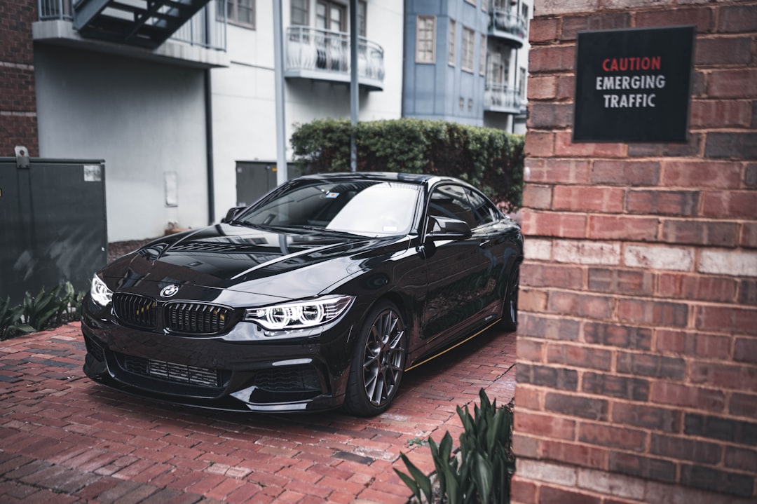 black mercedes benz coupe parked beside brown brick wall