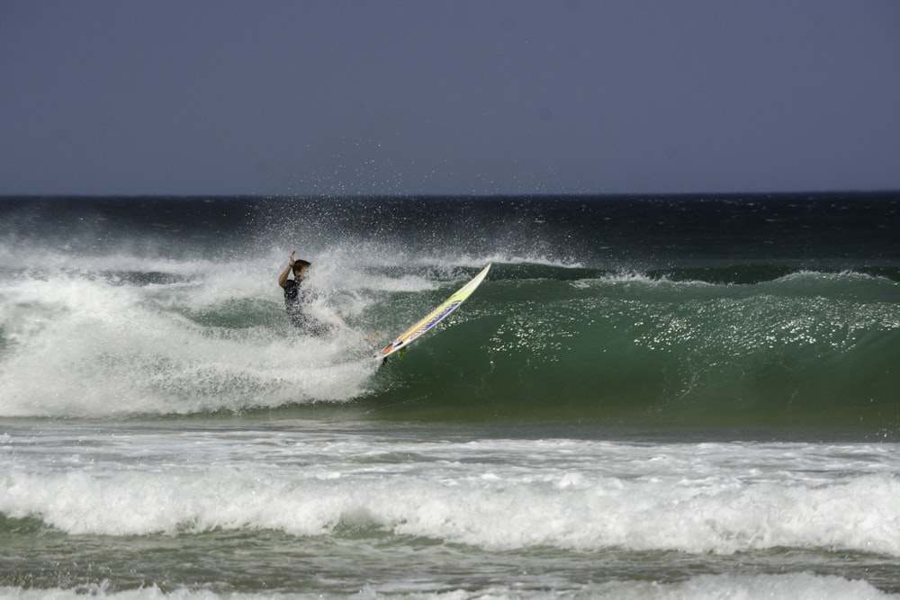 man surfing on sea waves during daytime