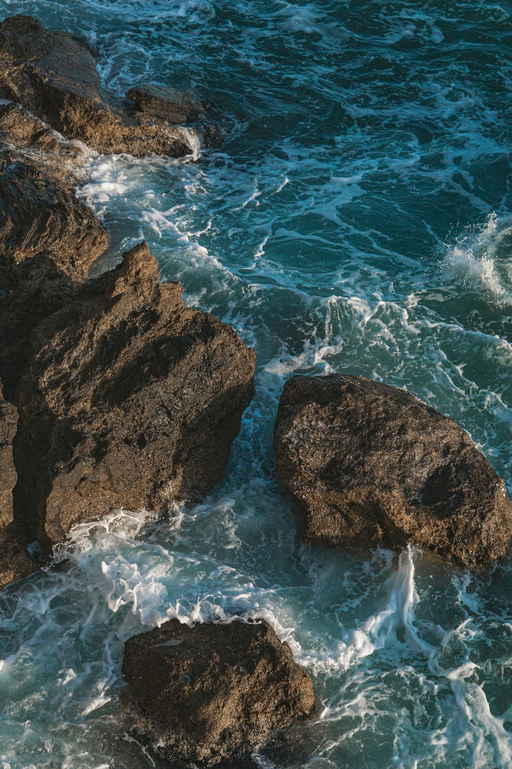 formazione rocciosa marrone sullo specchio d'acqua durante il giorno