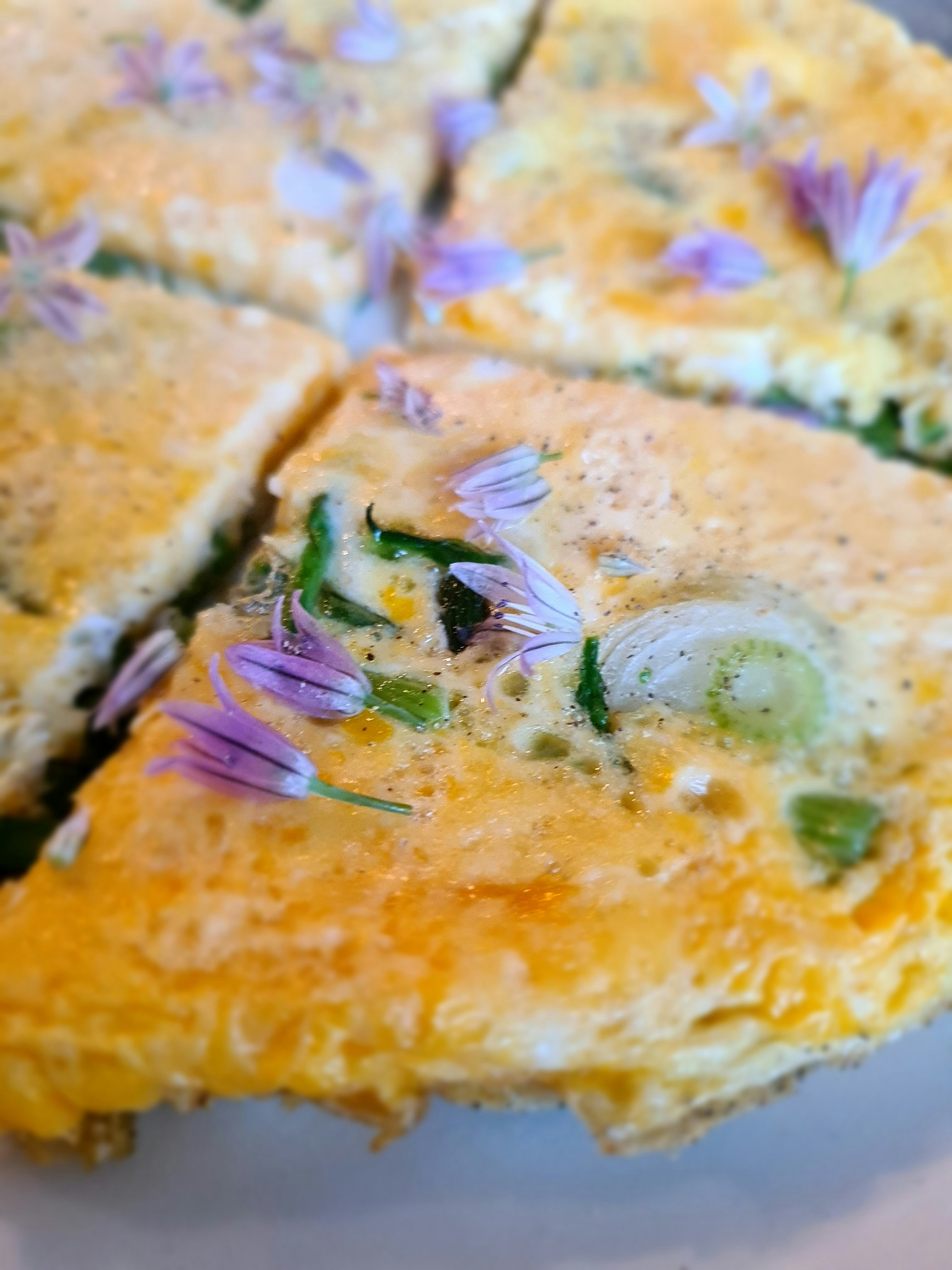 Fluffy omelette on toasted bread with herbs, dark plate on dark wooden surface