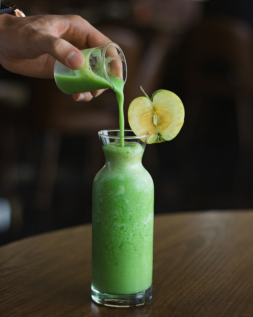 person holding green fruit shake