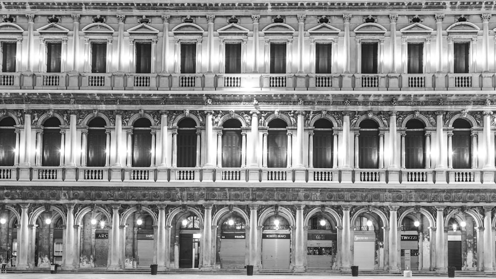 grayscale photo of people walking on street near building