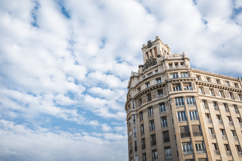 white concrete building under blue sky and white clouds during daytime