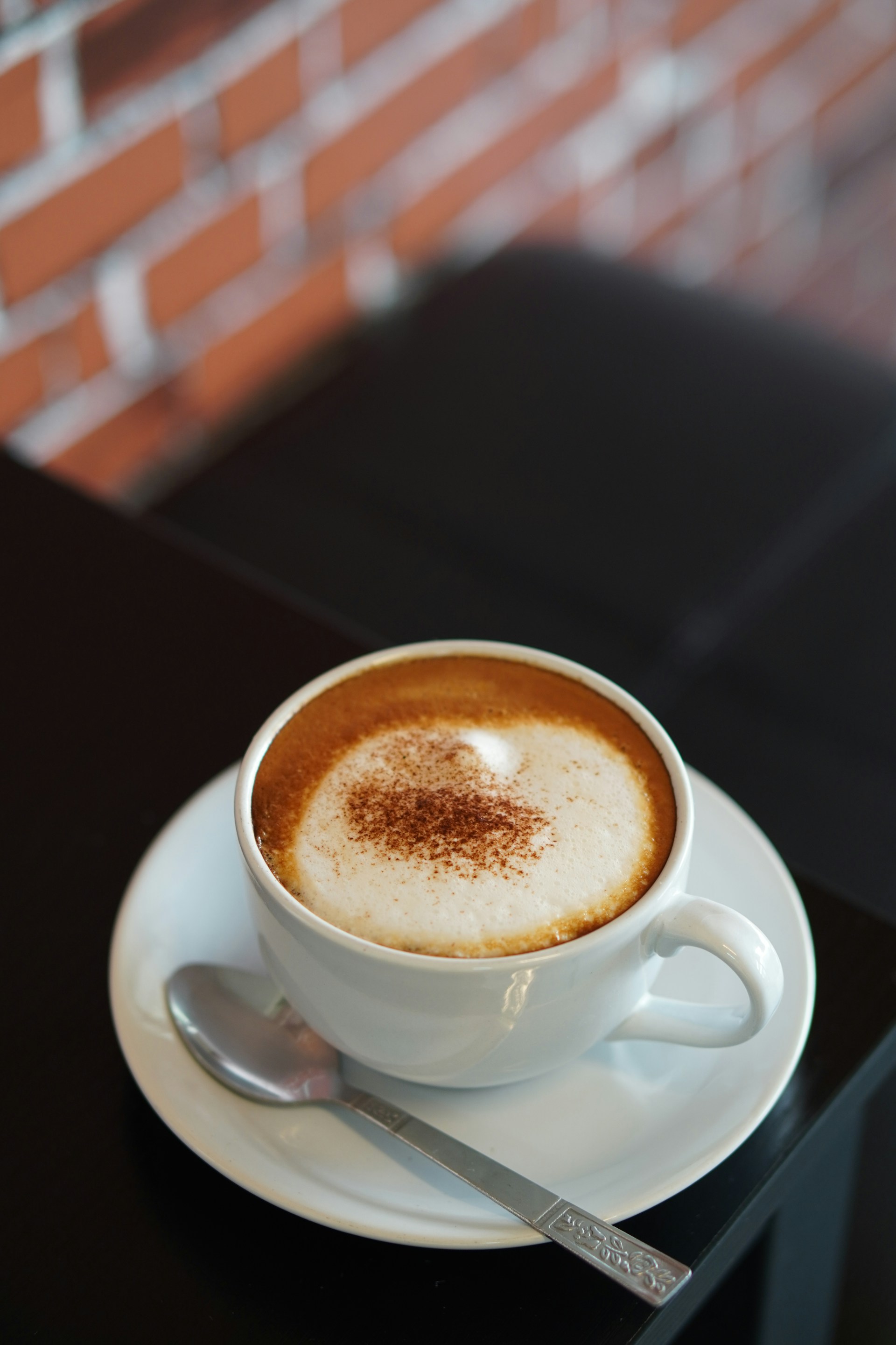 white ceramic mug with brown liquid inside