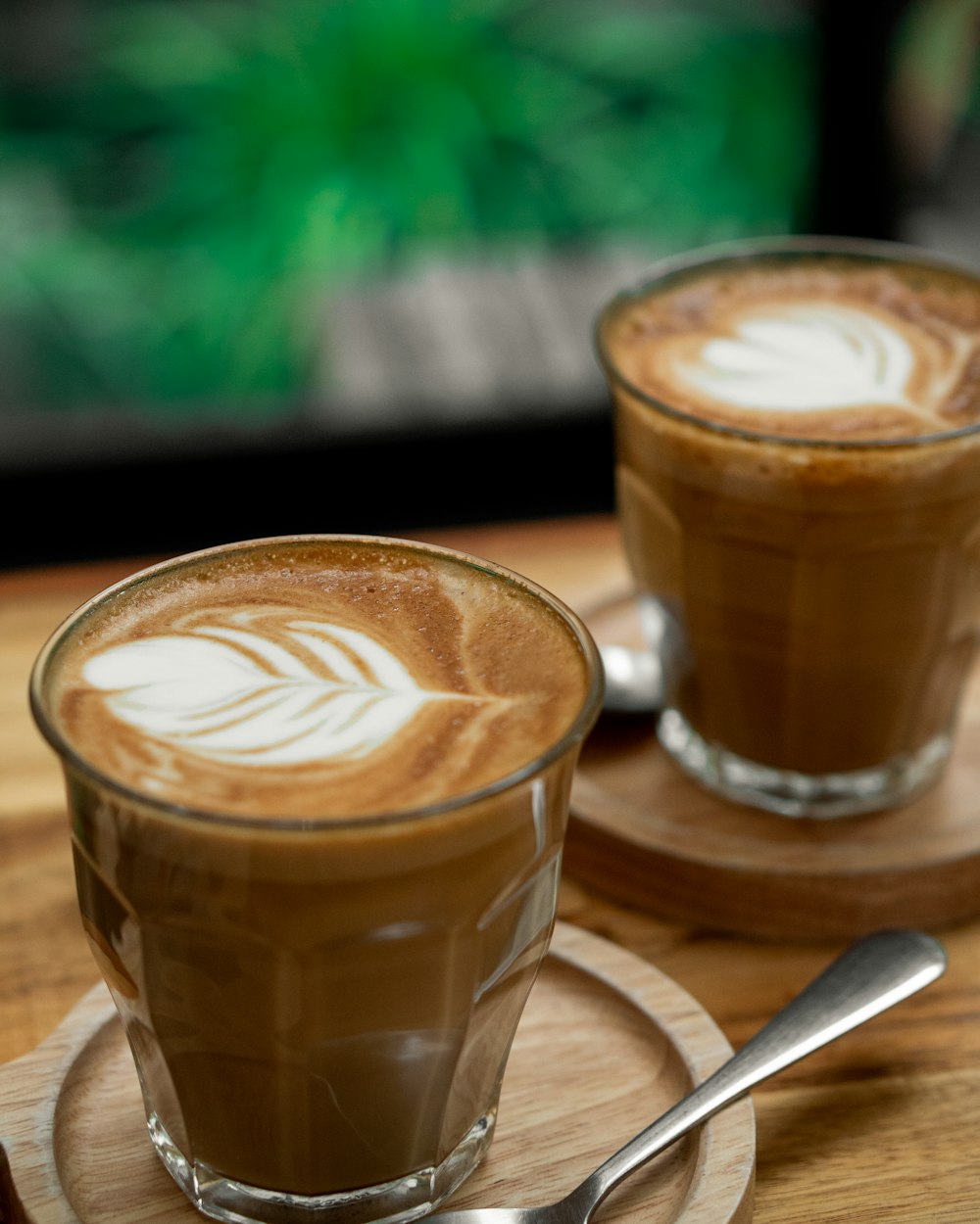 brown and white coffee in clear glass mug on brown wooden table