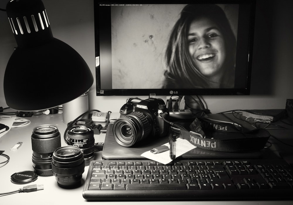 black flat screen computer monitor beside black dslr camera