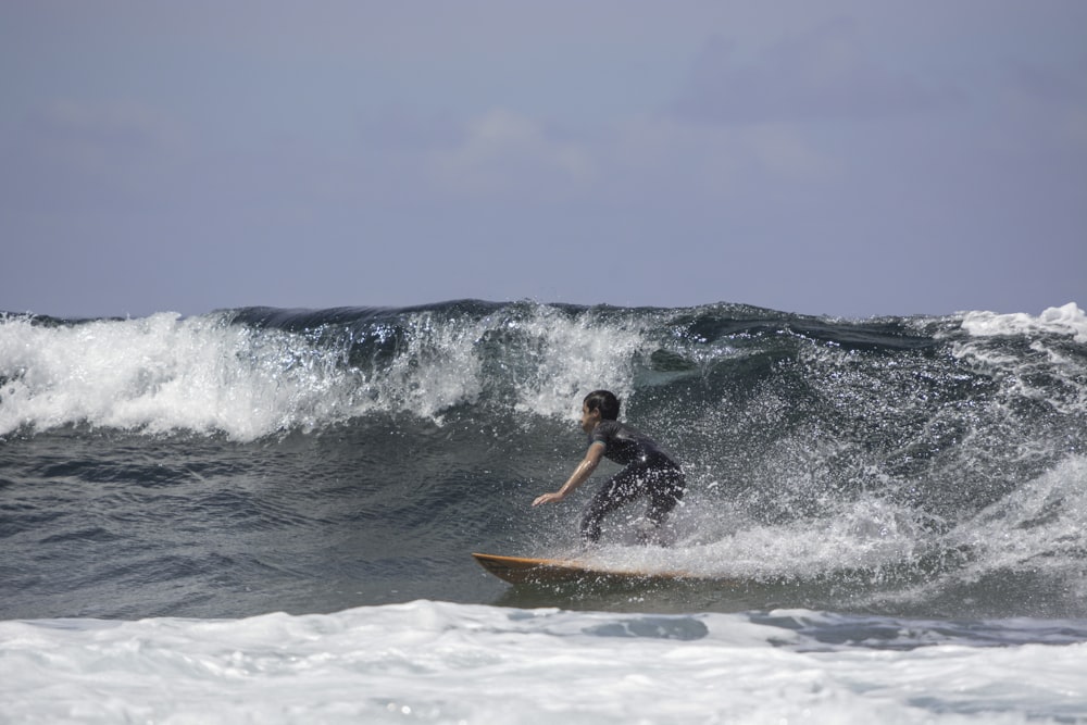 man surfing on sea waves during daytime