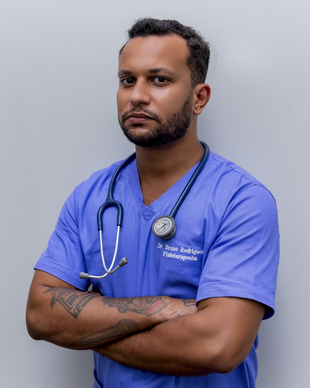 homme en t-shirt à col rond bleu portant un stéthoscope bleu