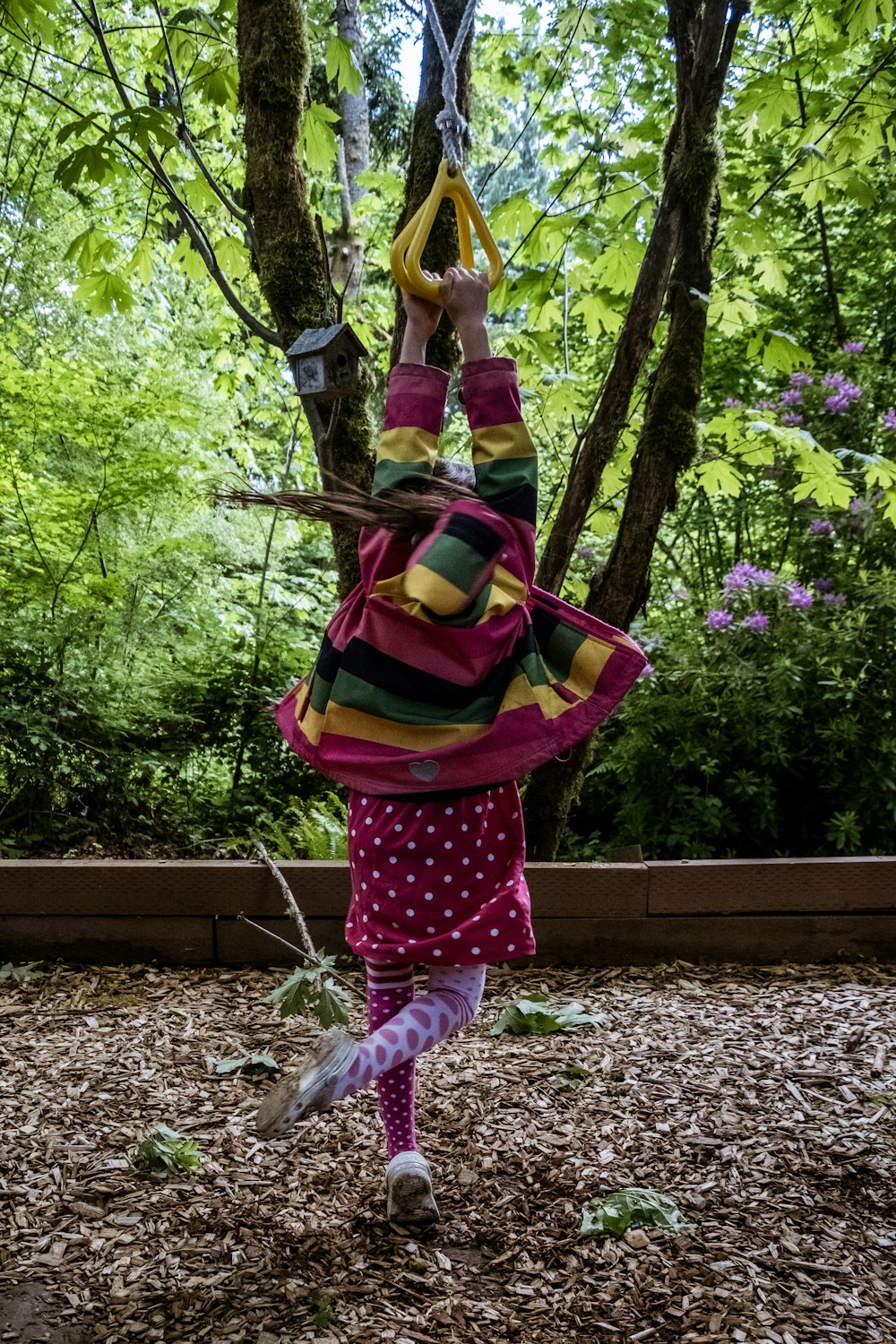 girl in pink and white polka dot pants carrying backpack