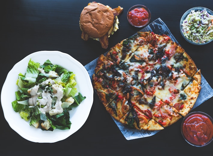 pizza with green vegetable on white ceramic plate