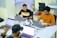 A diverse group of students collaborating on laptops in a bright, modern study space.
