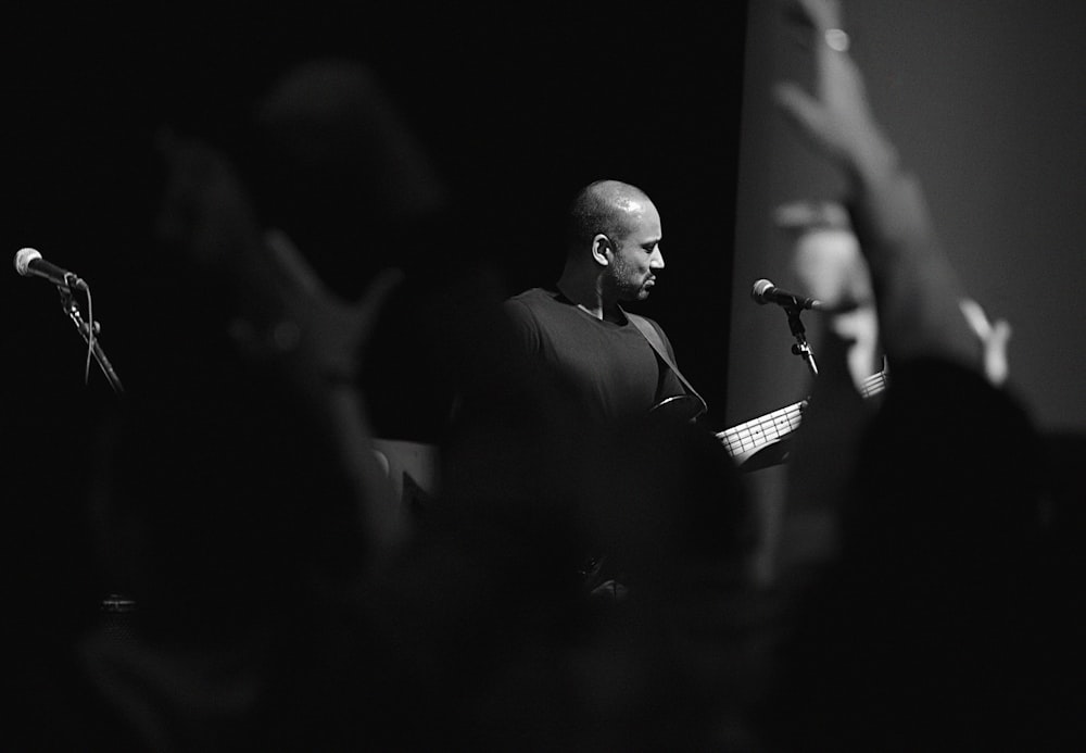 man in black shirt standing in front of microphone