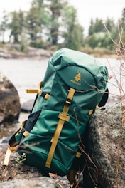 green and brown backpack on rock