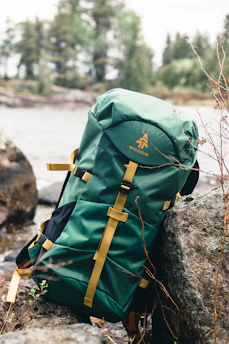 green and brown backpack on rock