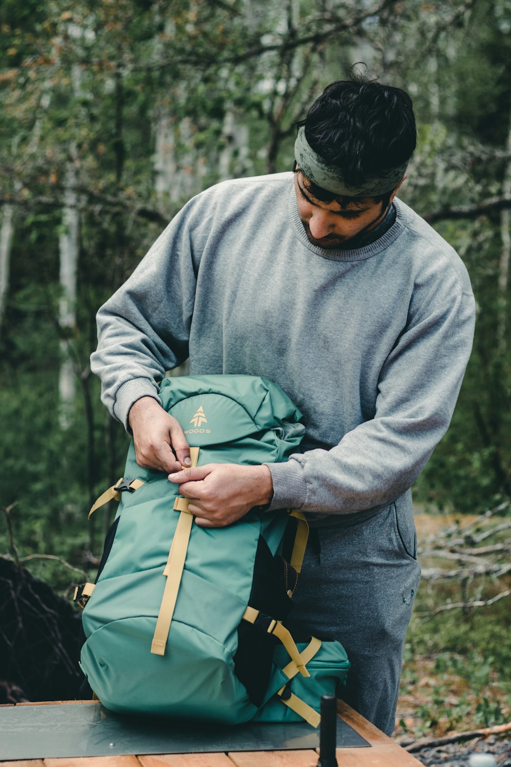 man in gray sweater holding brown stick