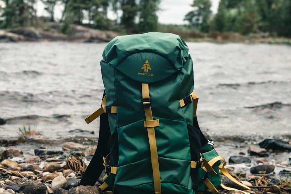 Outdoor backpack sitting on a log beside a stream — essential gear for a day in the field