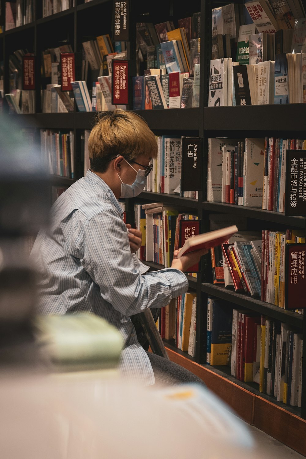 man in gray and white pinstripe dress shirt reading book