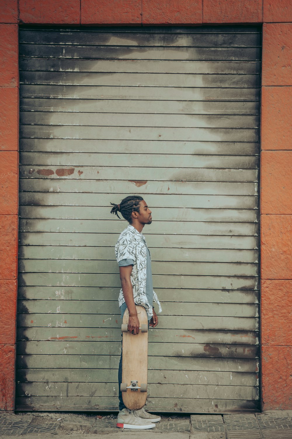 man in white and black checkered button up shirt and black cap standing beside brown wooden