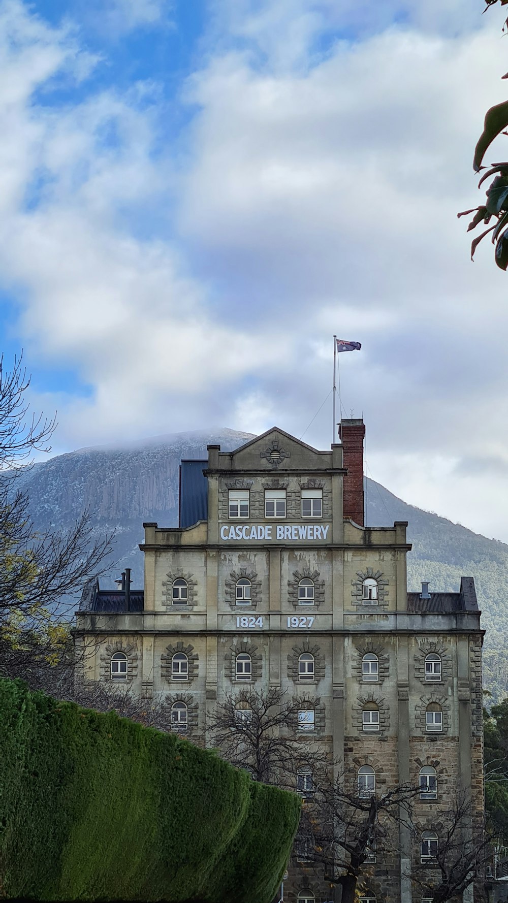 brown concrete building near mountain under white clouds during daytime