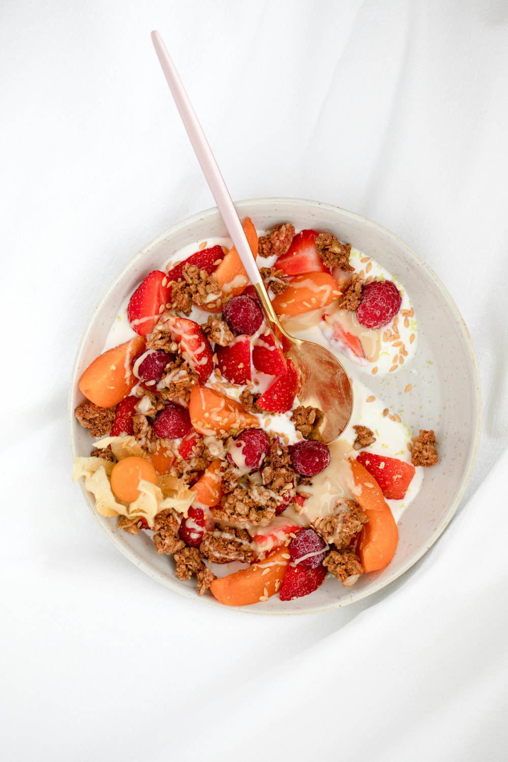 cereal with sliced strawberries and cream on white ceramic bowl