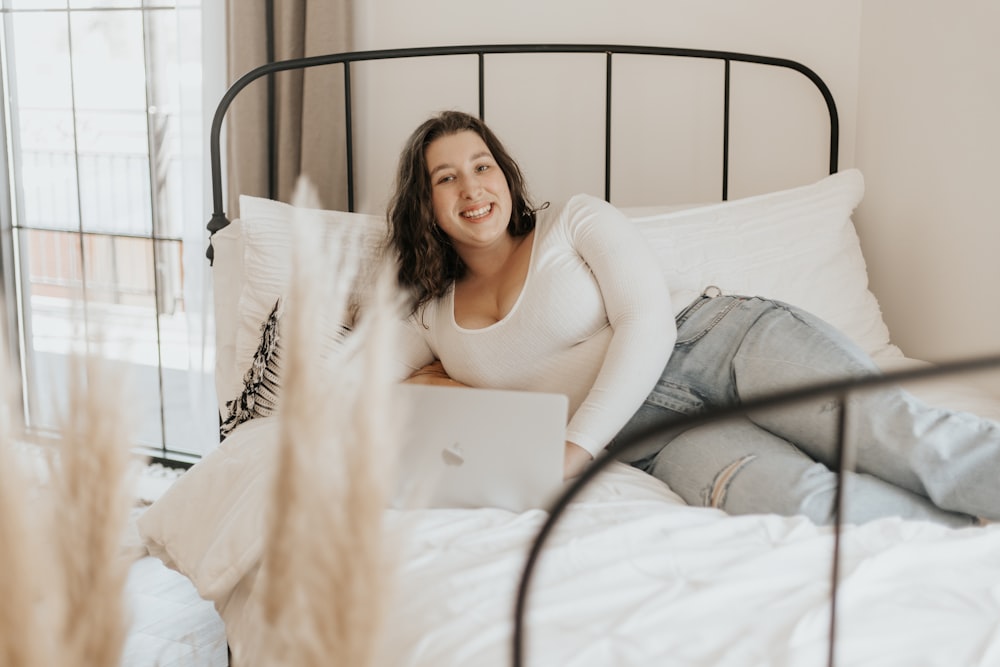 woman in white long sleeve dress lying on bed