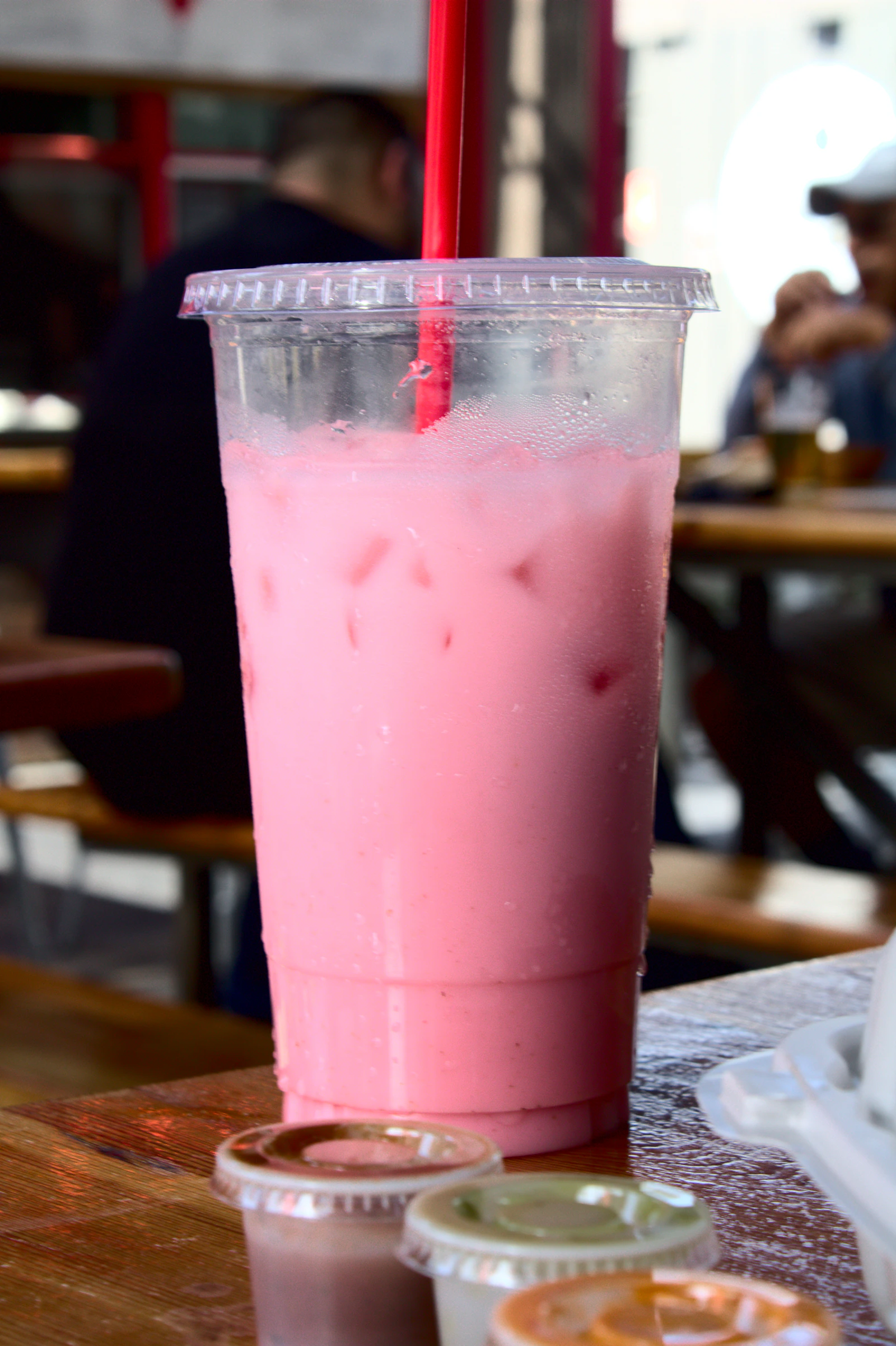 A chilled agua fresca served in a to-go cup with a straw