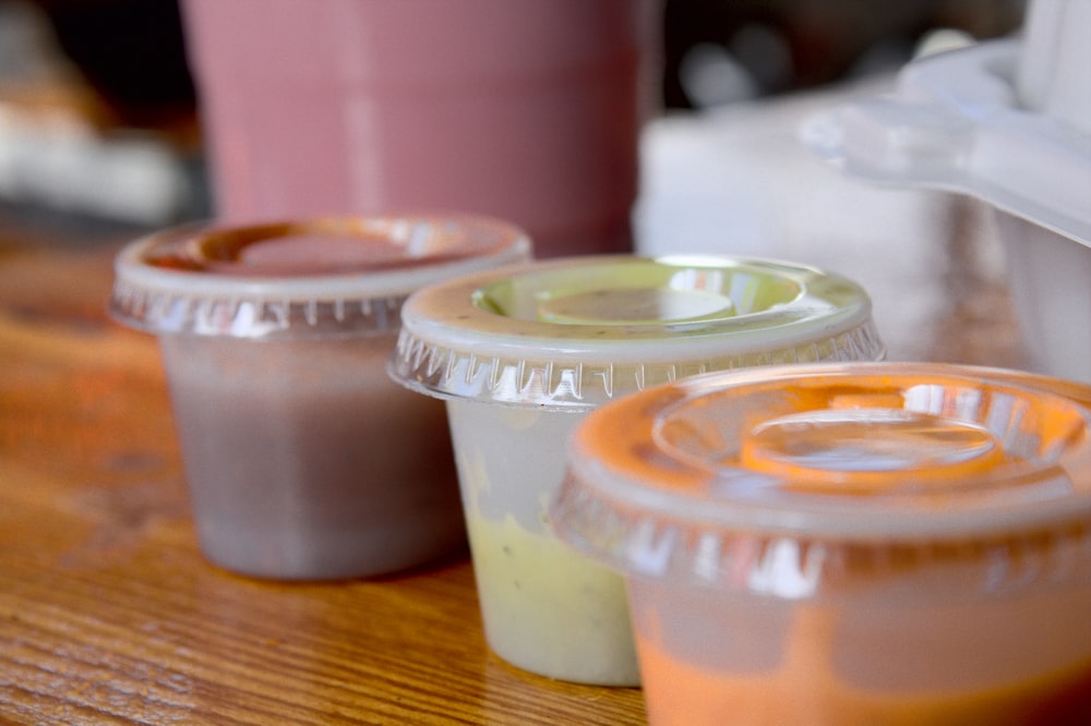 four white plastic cups on brown wooden table