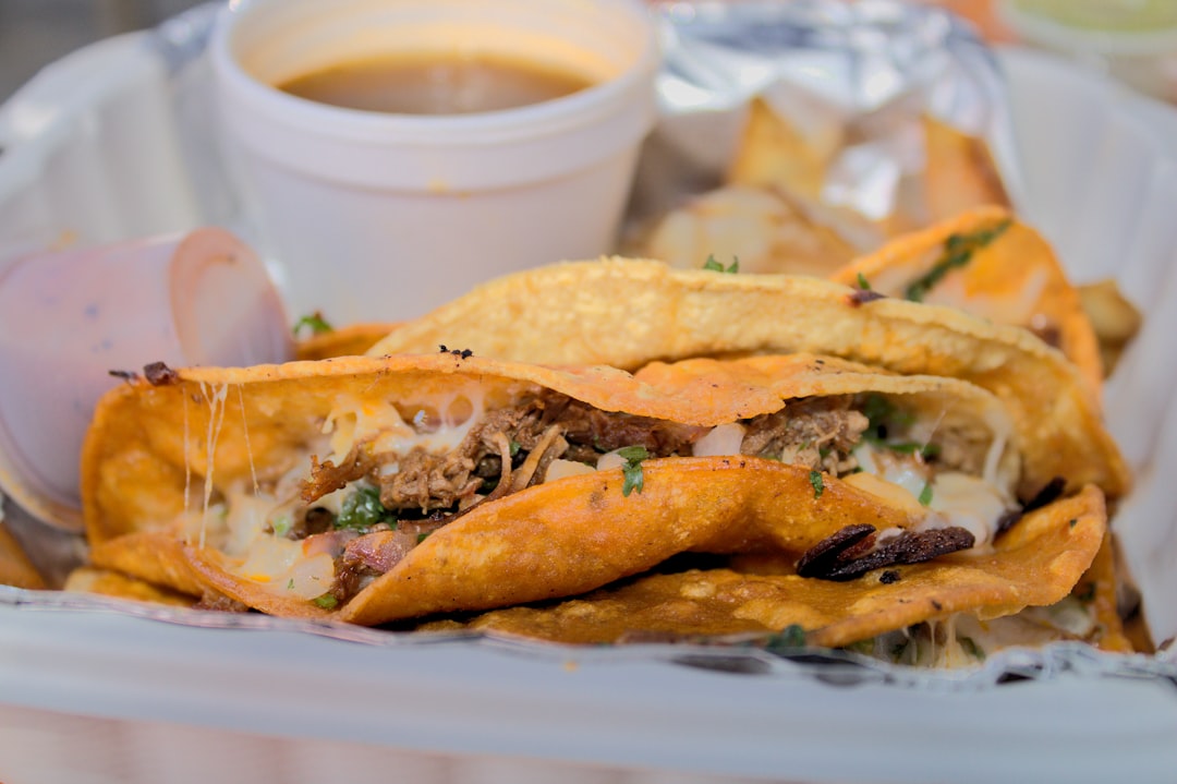 bread on white plastic container, 3 Birria tacos with cheese and birria juice at Steelcraft in Long Beach