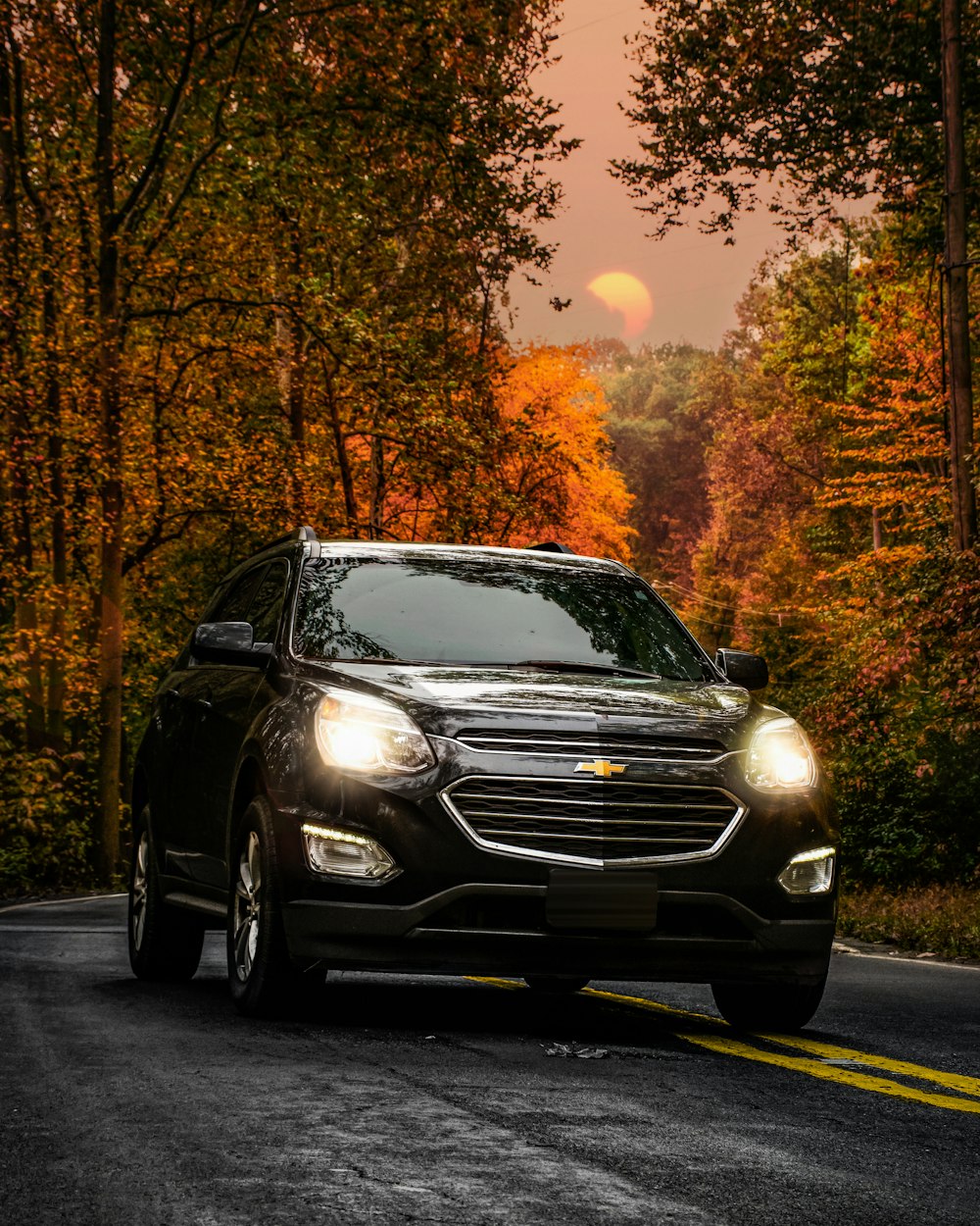 Coche Mercedes Benz negro en la carretera durante la puesta del sol