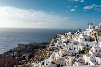 white concrete houses near sea under blue sky during daytime