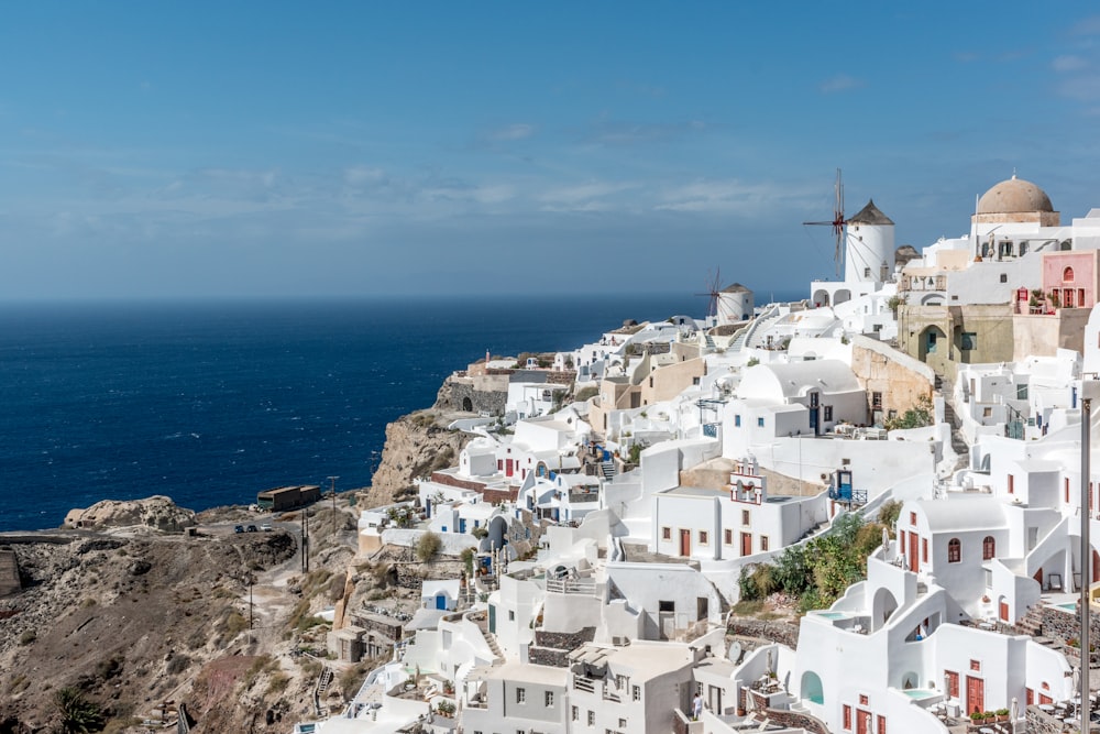 white concrete houses near sea under blue sky during daytime