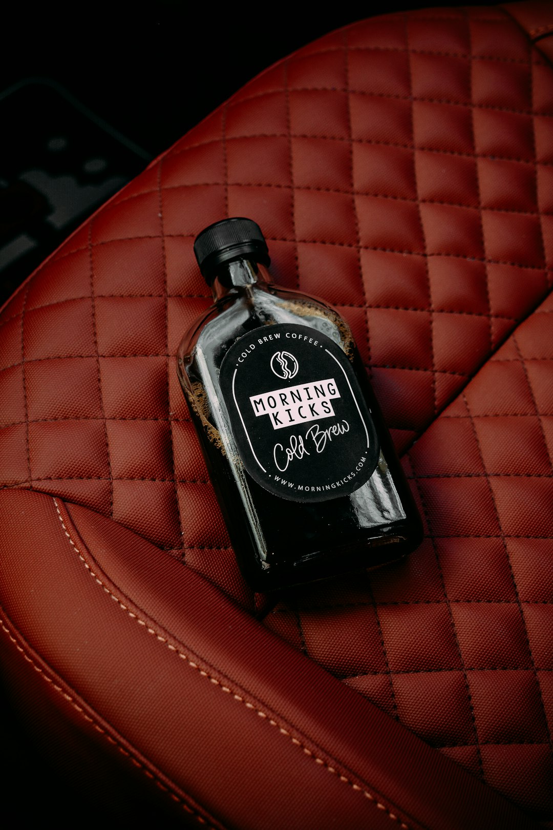 black and silver jack daniels bottle on red leather textile