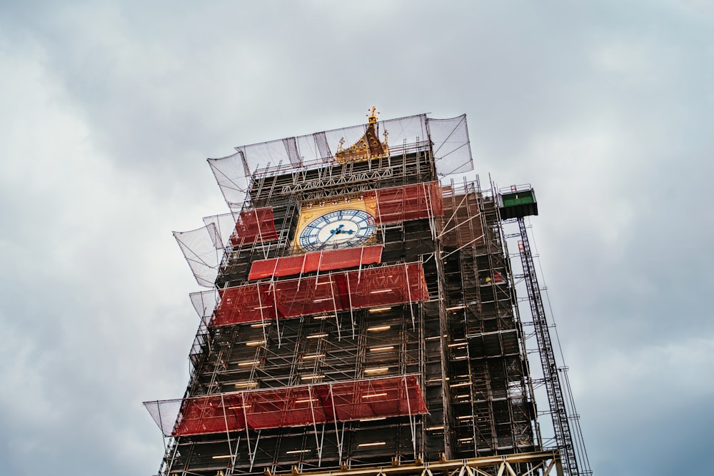 Torre roja y negra bajo el cielo blanco durante el día