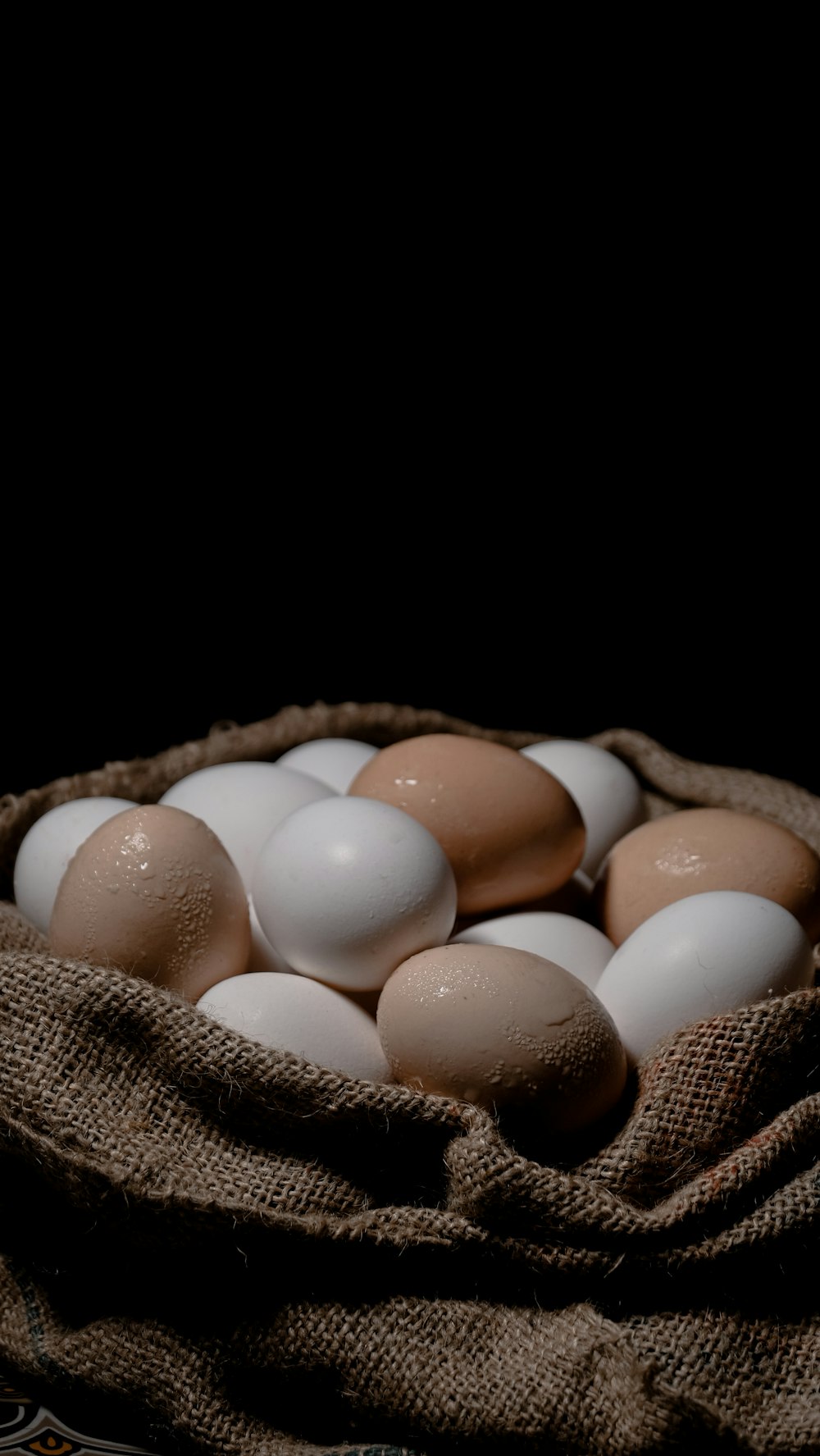 white and brown egg on brown woven basket