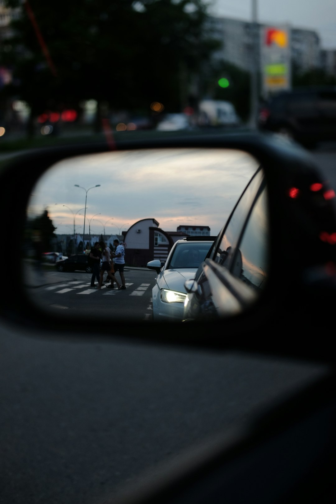 car side mirror showing cars on road during daytime