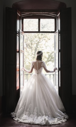 Bride framed in open balcony doors—Premium Glasgow wedding film portrait.