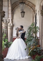 woman in white wedding gown standing beside green plants