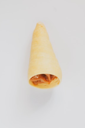 Close-up of a rich, dark chocolate cone drizzled with caramel.