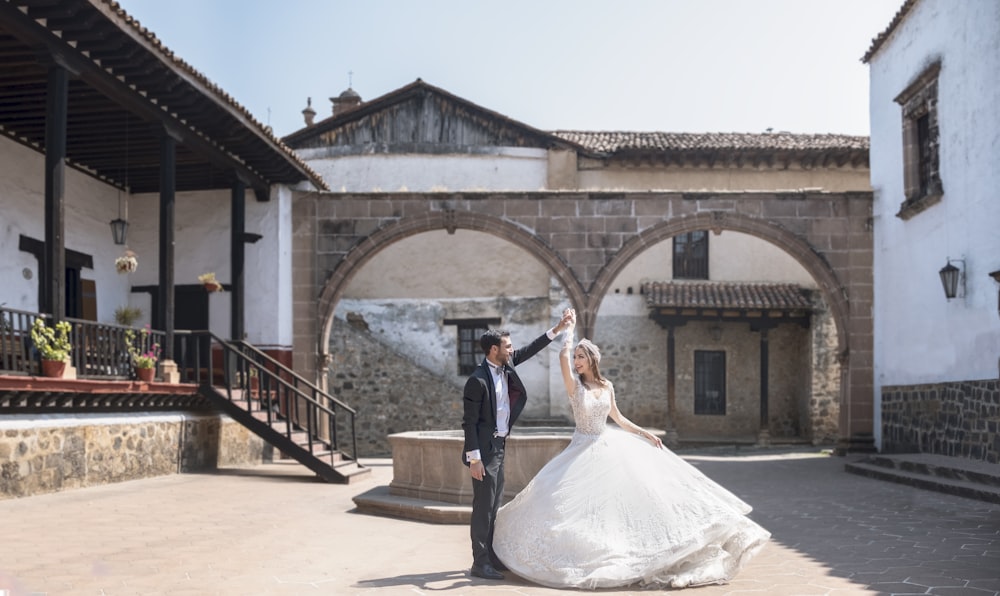 man and woman standing on brown concrete bridge during daytime