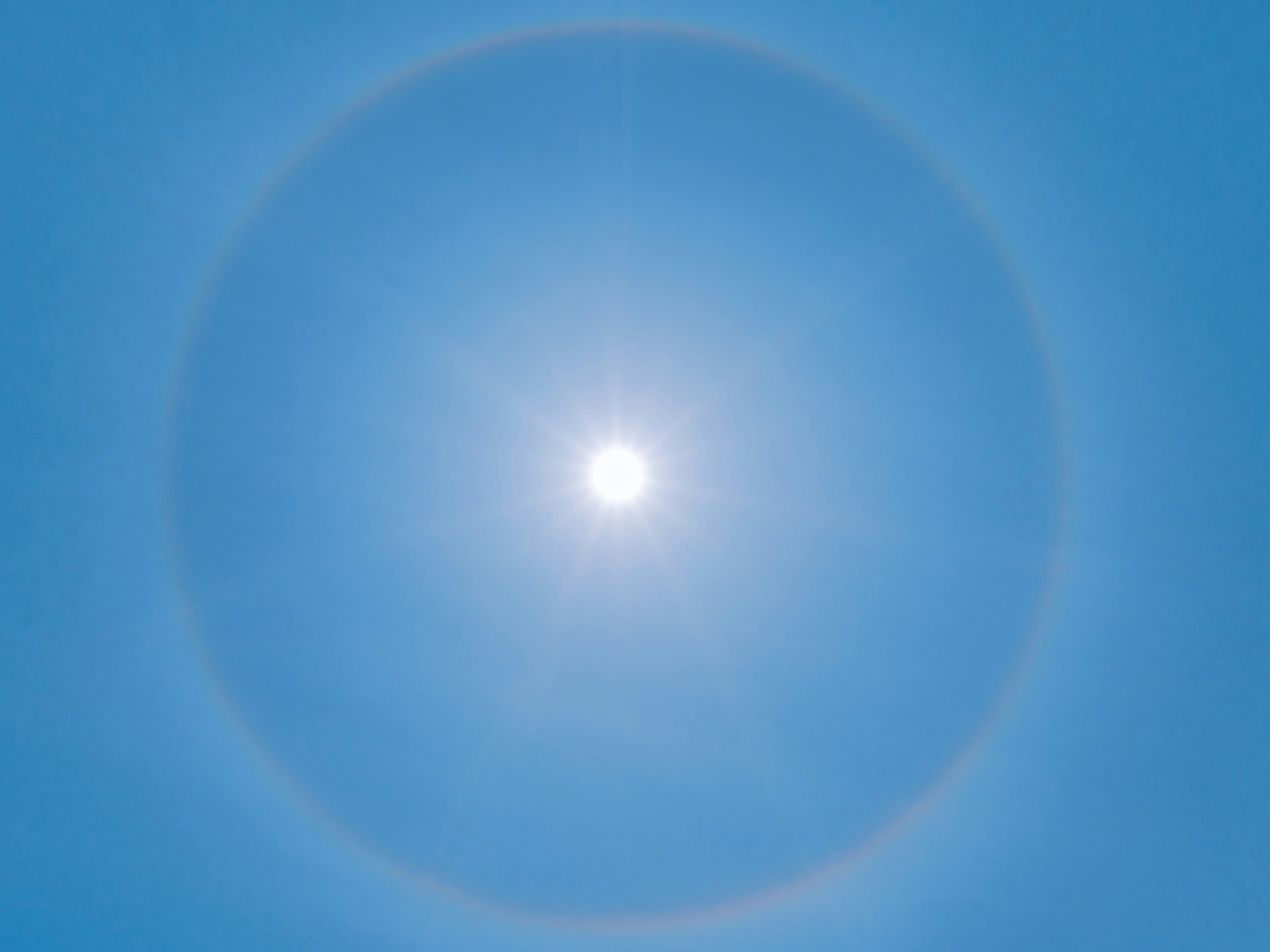 Photo of a sun halo on a clear blue sky