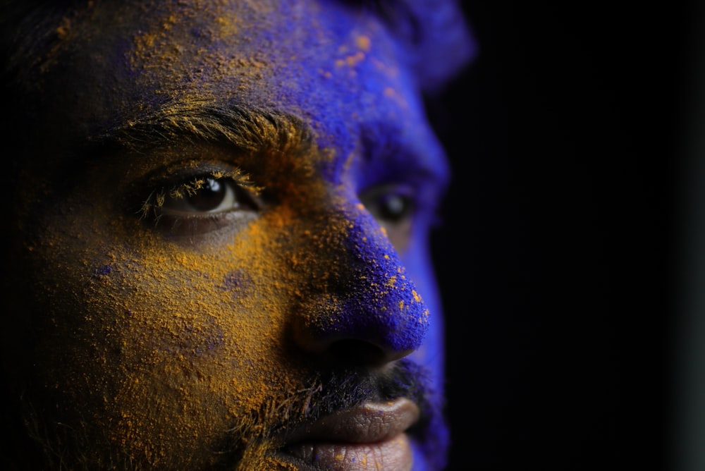 man with purple and blue powder on face