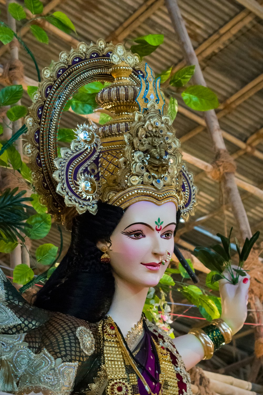 woman in green and gold floral dress wearing gold crown