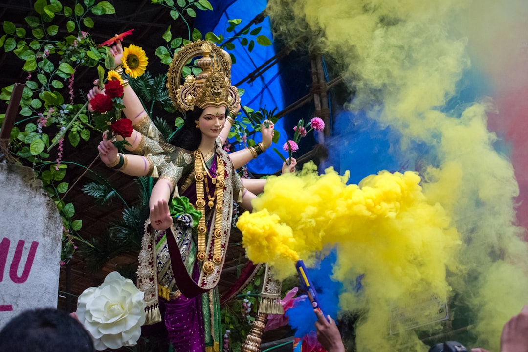woman in purple and gold traditional dress, A beautiful idol of Maa Durga at a workshop in Mumbai during Navratri 2019