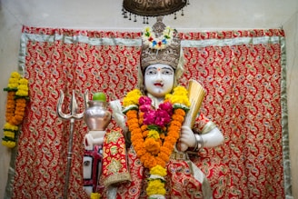 woman in red and gold sari dress holding white ceramic mug