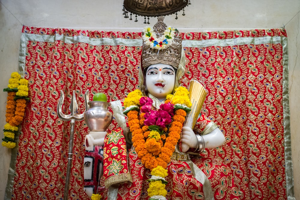woman in red and gold sari dress holding white ceramic mug