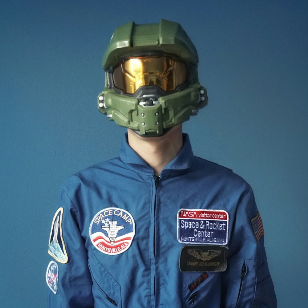 man in blue and white zip up jacket wearing green helmet