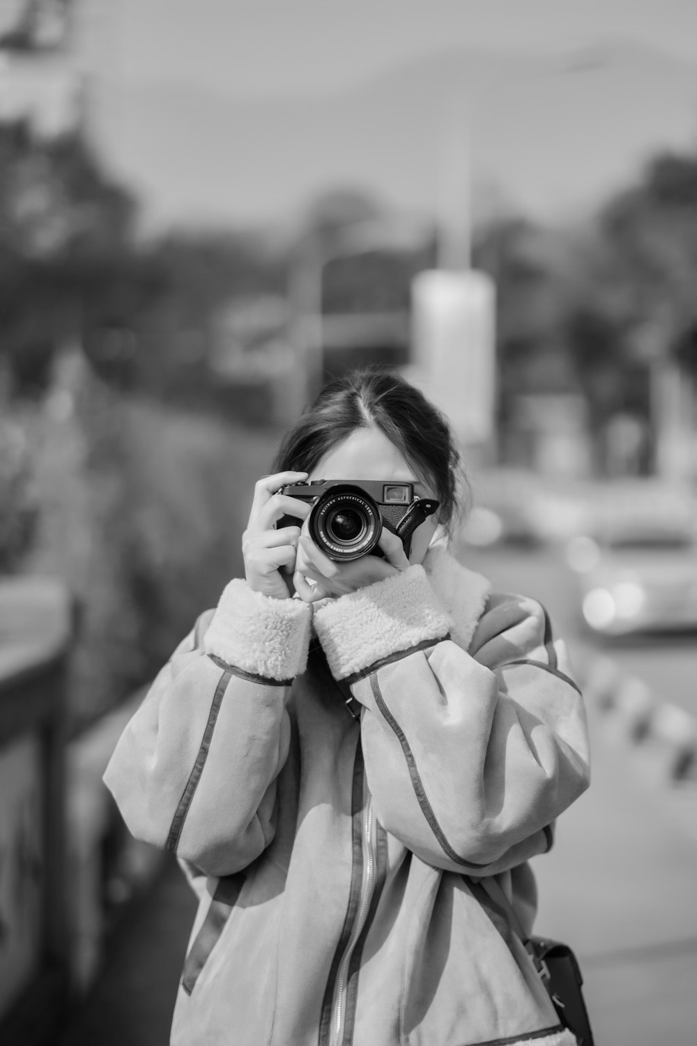 grayscale photo of woman holding camera